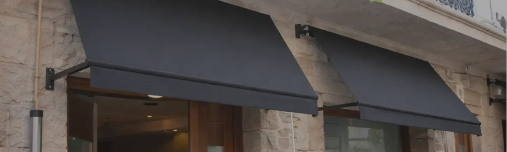 Toldos punto recto negros sobre las puertas de un local comercial